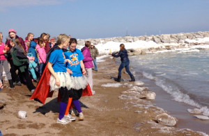 Teachers Tonya Langlois and Jennifer Voigt, in capes and tutus, get set to take a plunge in Lake Huron. (Image by Mindy Bruning)