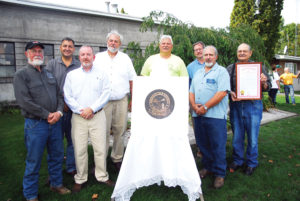 COMMEMORATING THE Presque Isle County Road Commission’s 100 years of service to county residents were, front from left, road commissioner Ronald Bischer; Scott Thayer, MDOT north region engineer; road commissioner Thomas Catalano; back, State Sen. Jim Stamas, former superintendent/manager Eric Rose; superintendent/manager Jerry Smigelski; Mark Straley, county engineer, RS Scott Associates; and road commission chairman Chuck Rhode.  (Photo by Peter Jakey)