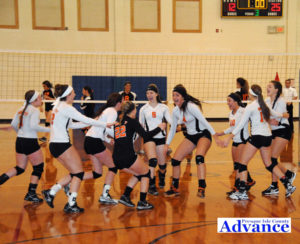 Huron volleyball players celebrate the winning point in the district championship contest. (Photo by Richard Lamb)