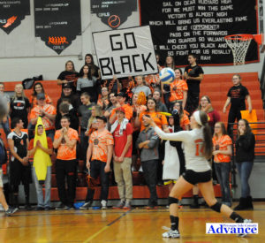 Kayla Rabeau tees up the winning point as her classmates cheer her on. (Photo by Richard Lamb)
