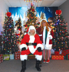SANTA AND one of his helpers, Karen Silver, get ready to visit with children at the Presque Isle County Historical Museum. Last week Santa lit Westminster Park, decorated by the Rogers City Optimist Club. (Photo by Richard Lamb)
