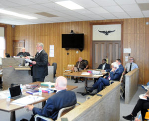 PROSECUTING ATTORNEY Ken Radzibon told the jury why the defendant should be found guilty in his opening statement as the Honorable Judge Scott Pavlich looks on. At right, are defense attorney Dan White and Rev. Sylvestre Obwaka.(Photos by Richard Lamb)
