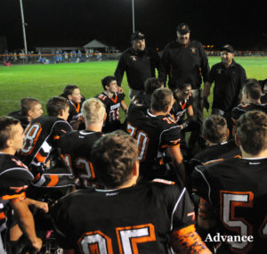 Coach Cory Malocha (back at right) addresses his team after a 14-7 win over Inland Lakes Aug. 31. (Photo by Richard Lamb)