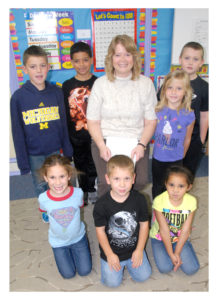 ST. JOHN Lutheran School teacher Laurie Maynard has been named Rogers City’s teacher of the year. She teaches kindergarten and first-grade in the morning and adds second-graders in the afternoon. Here, her students managed to stand still for a moment, and only a moment, to pose with their award-winning teacher. (Photo by Peter Jakey)