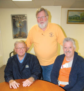 STALWARTS FOR youth, Rogers City Optimist Club members live by the motto, “friends of youth.” Some of the leaders of the club are, from left, Richard Wozniak, Terry Larson (standing) and Mike Marx. They are gearing up for the Christmas lighting in a few weeks and have a few more sponsorships to sell. (Photo by Peter Jakey)