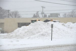 Somewhere on the other side of that snow mountain, is Huron National Bank. City and county crews are doing their best to clear the roadways and parking lots after the weekend storm. (Photo by Richard Lamb)