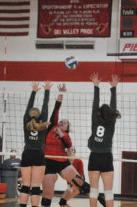 SENIOR SUNNY Flory, hitting from the right-side squeezed this spike through a pair of Forest Area blockers at home Tuesday. (Photo by Angie Asam)