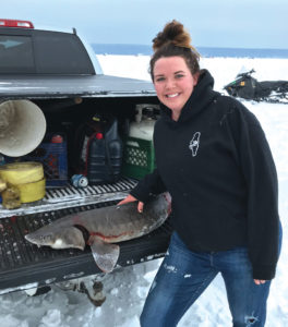 KEEPING WITH a recent trend, the 2019 sturgeon season was completed in 90 minutes or less for the third-straight year. In 2017, it took only 66 minutes. This year, it was 78 minutes. Here, Stephanie Miller stands in the spotlight with one of the six sturgeon that were harvested. She took the second fish at 8:23 a.m.. it was a male measuring 52.3 inches and weighing 27.7 pounds. (Photo courtesy of Walter Elyse, MDNR fisheries division)