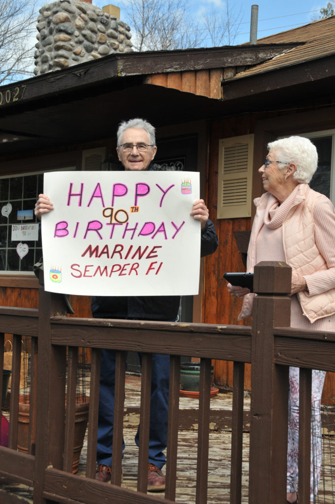DON CLINE, who is flanked by his wife Ann, stood on the porch of their home as friends (not pictured) sang “Happy Birthday” to the veteran. (Photo by Peter Jakey)